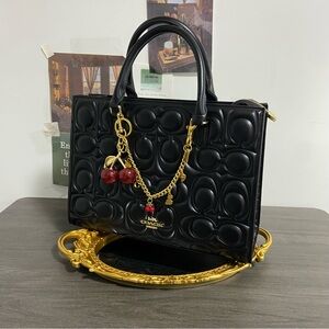 Coach Black Embossed Satchel with Gold Accents and Red Charm
